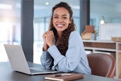 Smiling woman working on laptop in office