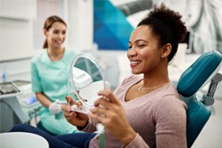 Patient looking at reflection in handheld mirror